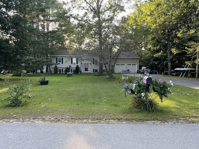 view of front of property with a front lawn, a garage, and driveway