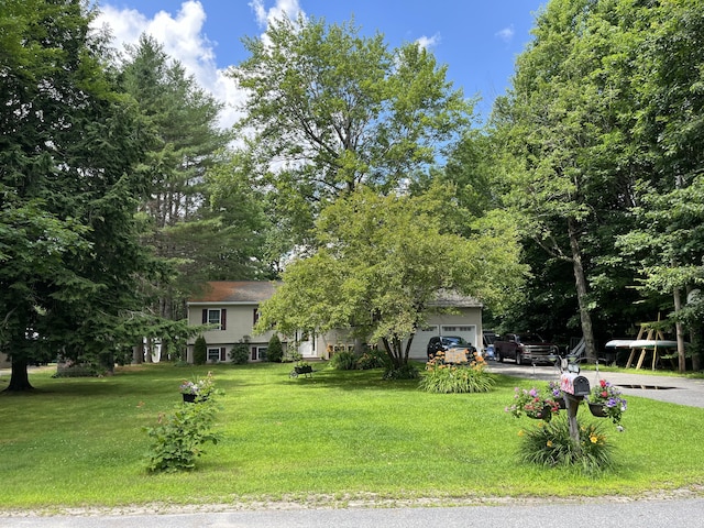 view of front facade featuring a garage, driveway, and a front lawn