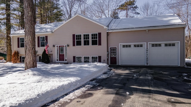 bi-level home featuring an attached garage and driveway