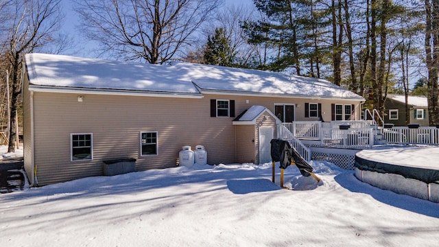 snow covered house with a wooden deck