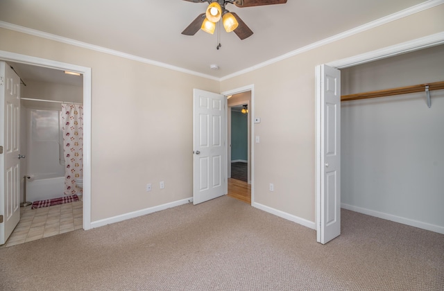 unfurnished bedroom with a closet, baseboards, carpet, and crown molding