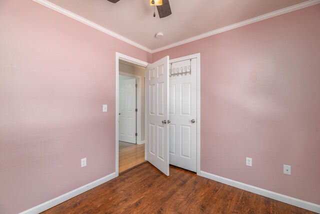 unfurnished bedroom with baseboards, dark wood finished floors, ceiling fan, ornamental molding, and a closet