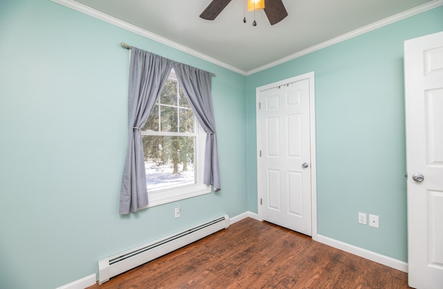 unfurnished bedroom featuring a baseboard heating unit, dark wood finished floors, baseboards, and ornamental molding