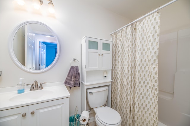 bathroom with curtained shower, toilet, and vanity