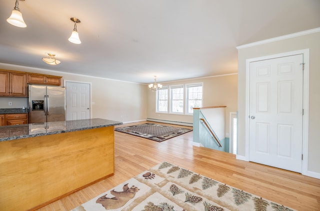 kitchen with crown molding, pendant lighting, light wood-style flooring, brown cabinets, and stainless steel refrigerator with ice dispenser