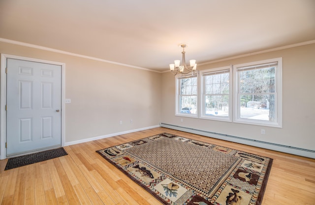 dining area with a chandelier, wood finished floors, baseboard heating, and ornamental molding