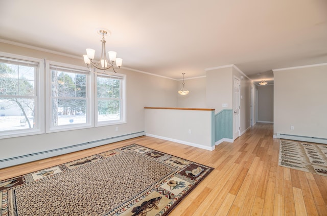 empty room featuring light wood finished floors, a baseboard heating unit, an inviting chandelier, and ornamental molding