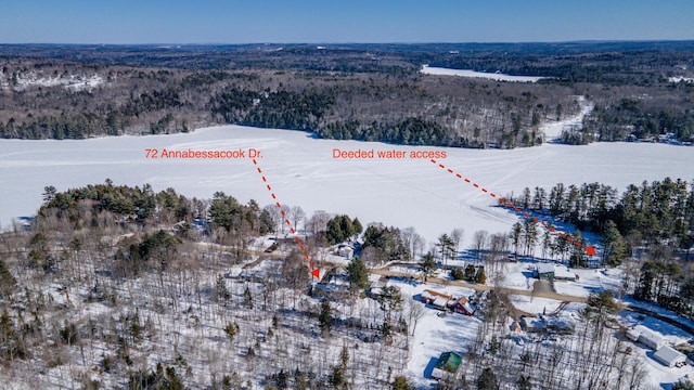 snowy aerial view featuring a forest view