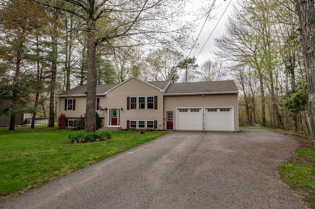 split foyer home featuring a garage, driveway, a front lawn, a shingled roof, and entry steps