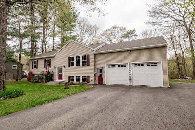 bi-level home featuring a garage, asphalt driveway, a front yard, and roof with shingles