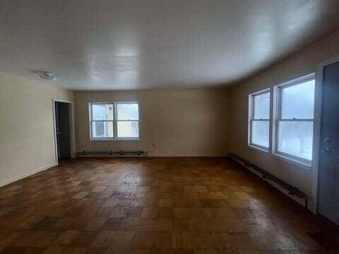 unfurnished room featuring baseboard heating and baseboards