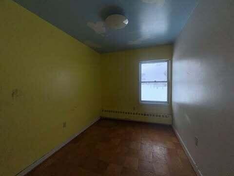 empty room featuring baseboards and baseboard heating