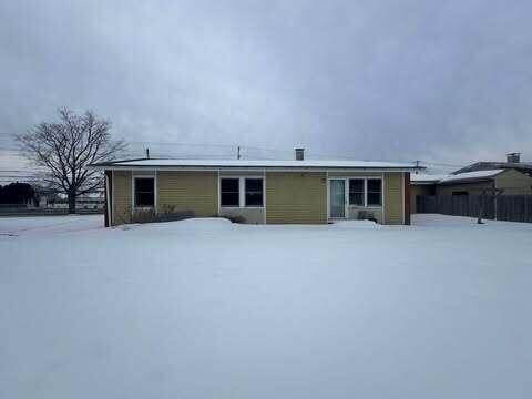 view of snow covered back of property