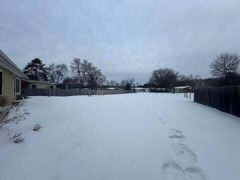 yard layered in snow featuring fence