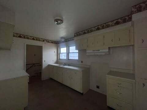 kitchen with under cabinet range hood and white cabinetry