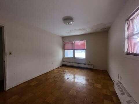 empty room with radiator heating unit and baseboard heating