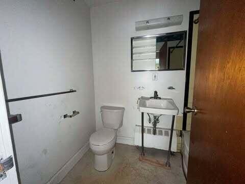 full bath with a bathtub, baseboards, a sink, and toilet