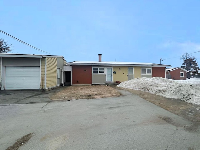 ranch-style home featuring driveway and a detached garage