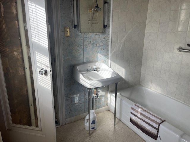 bathroom with baseboards, a bathing tub, and wallpapered walls