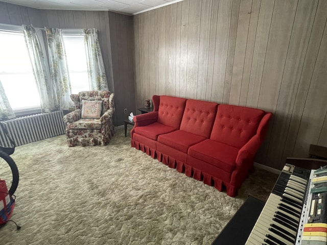 carpeted living area with wooden walls