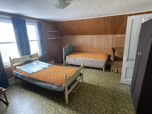 bedroom with vaulted ceiling and wooden walls