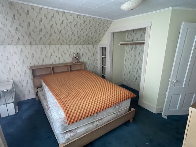 bedroom featuring dark colored carpet, a closet, vaulted ceiling, baseboards, and wallpapered walls