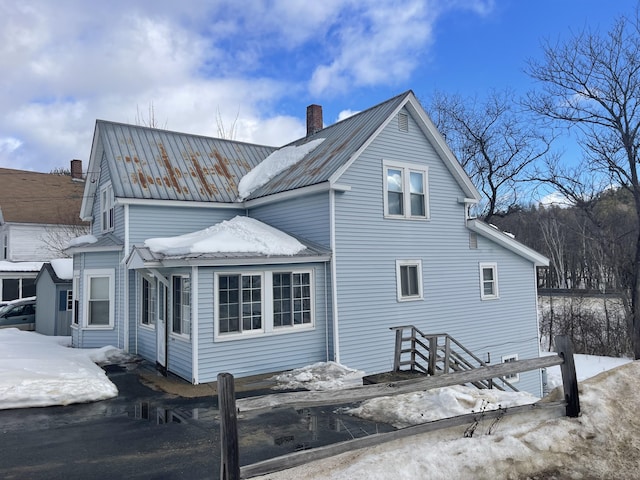 exterior space featuring metal roof and a chimney