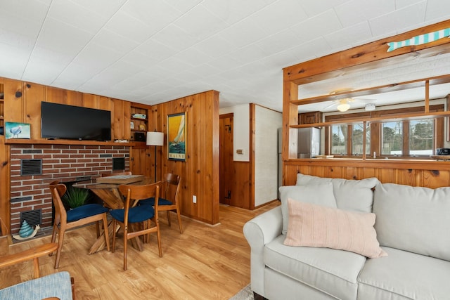 living room with wood walls and light wood-style flooring