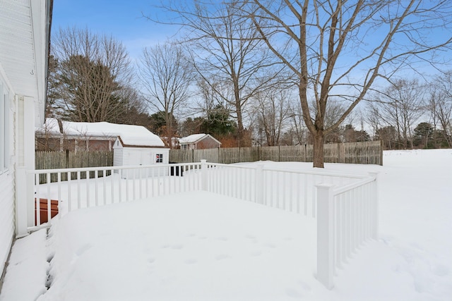 snowy yard with a fenced backyard and an outdoor structure