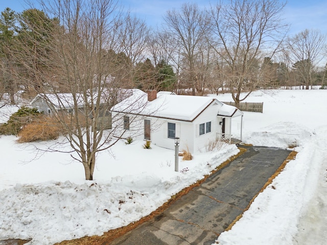 exterior space with a garage, aphalt driveway, and a chimney