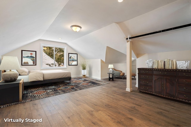 bedroom with dark wood-style floors, lofted ceiling, and baseboards