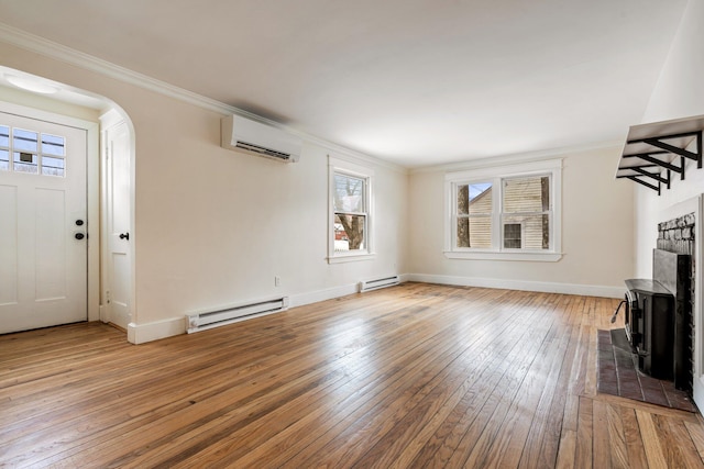 unfurnished living room with a baseboard heating unit, dark wood-style flooring, an AC wall unit, and ornamental molding