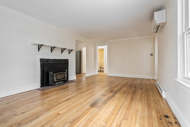 unfurnished living room featuring light wood finished floors, a baseboard heating unit, an AC wall unit, a wood stove, and baseboards