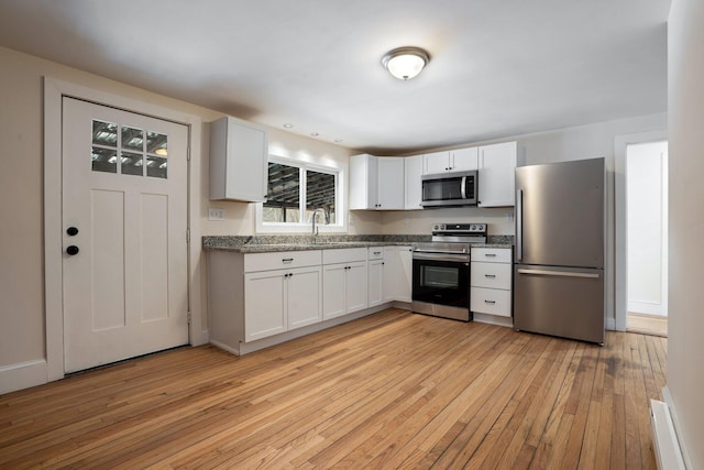 kitchen featuring appliances with stainless steel finishes, a sink, and white cabinets