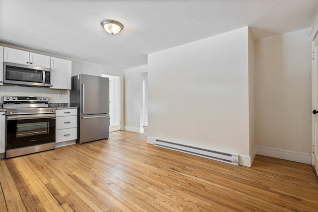 kitchen with light wood-style flooring, baseboards, white cabinets, appliances with stainless steel finishes, and baseboard heating