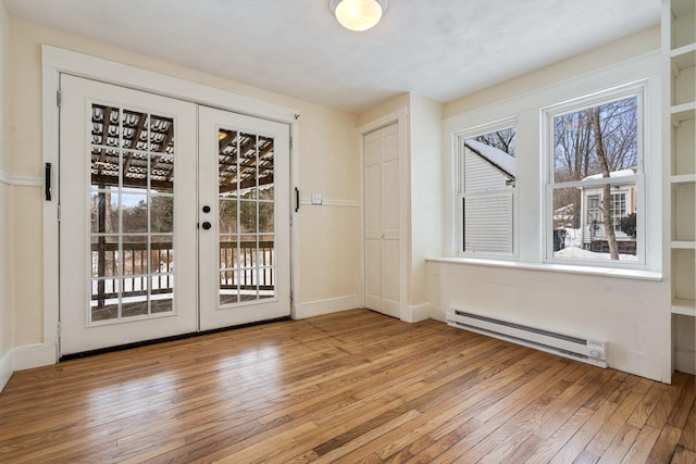 doorway to outside with a baseboard heating unit, french doors, light wood-type flooring, and a wealth of natural light