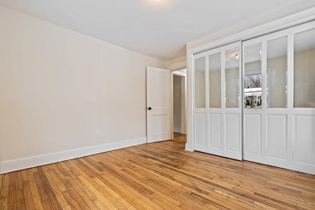 unfurnished bedroom with baseboards and light wood-style floors