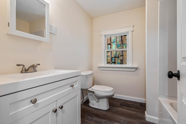 full bathroom featuring a bathtub, toilet, vanity, wood finished floors, and baseboards