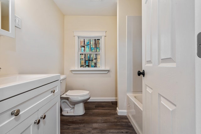 bathroom featuring baseboards, vanity, toilet, and wood finished floors