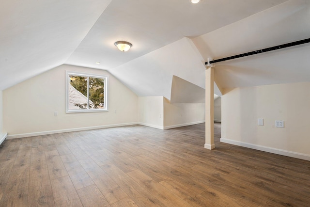 additional living space featuring lofted ceiling, wood finished floors, and baseboards