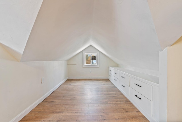 bonus room with baseboards, vaulted ceiling, and light wood finished floors