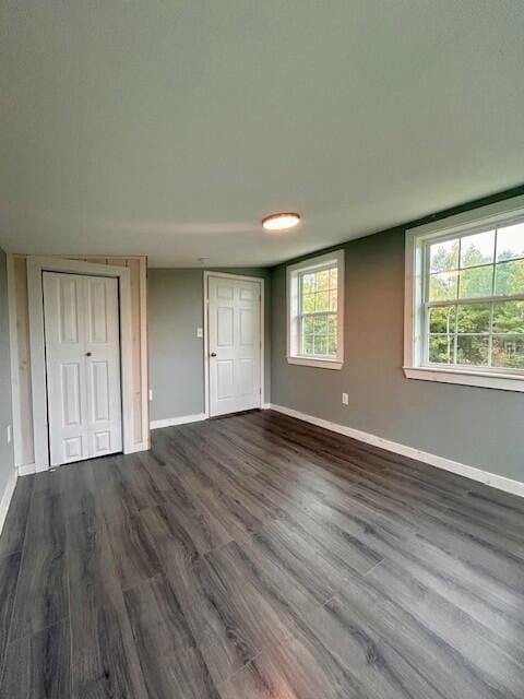 unfurnished bedroom featuring baseboards and dark wood finished floors