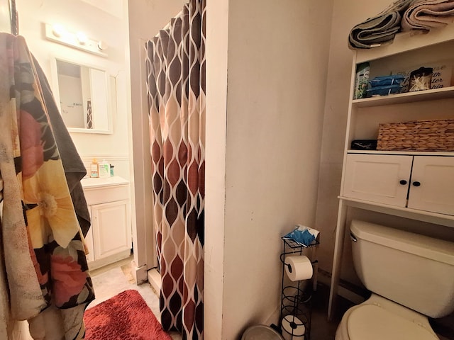 full bathroom featuring a shower with shower curtain, vanity, and toilet