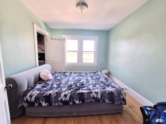 bedroom featuring baseboards and hardwood / wood-style flooring