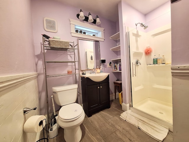 full bath featuring vanity, wood finished floors, a shower stall, and toilet