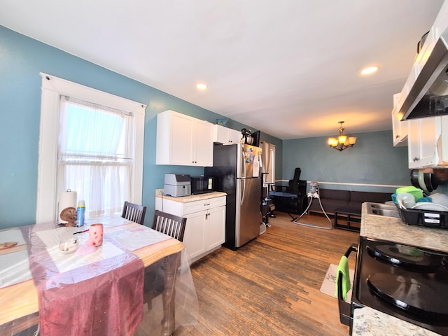 kitchen featuring electric range, white cabinetry, a notable chandelier, and freestanding refrigerator