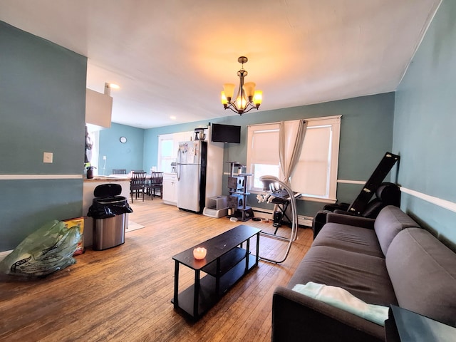 living room featuring a chandelier, light wood-type flooring, and baseboards