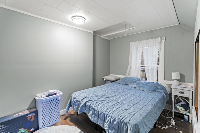 bedroom with attic access, lofted ceiling, and wood finished floors