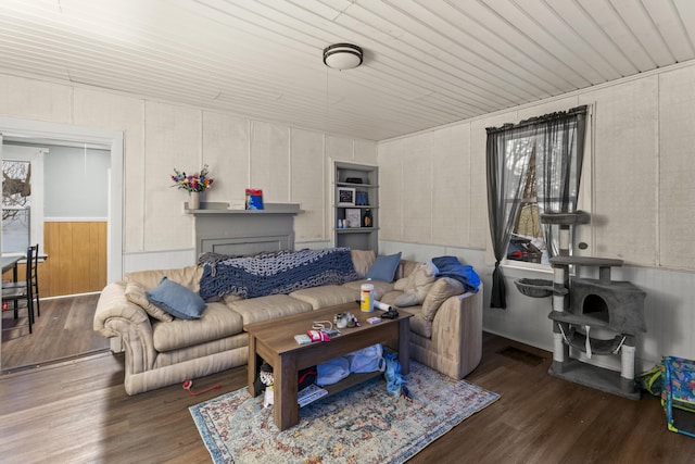 living room with dark wood-style flooring, wood ceiling, and a healthy amount of sunlight