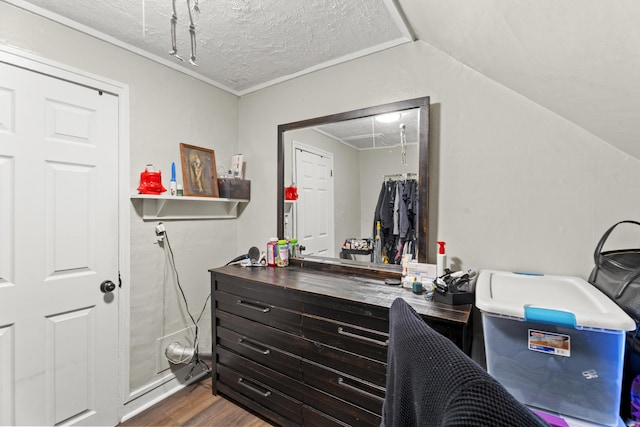 interior space featuring lofted ceiling, a textured ceiling, and wood finished floors